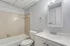 Bright and modern bathroom with elegant vanity, spacious mirror, and classic tile design offering a tranquil retreat.