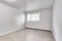 Bright empty room with sleek laminate flooring and large window, offering a versatile space to create your ideal living area.