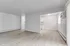 Bright and inviting living space with elegant wood flooring, large window, and open access to a cozy kitchen.