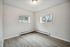 Bright room with modern light fixture, wood-style flooring, and large windows offering natural light and inviting views.