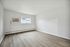 Bright, airy room with sleek laminate flooring and natural light streaming through a wide window, perfect for modern living.