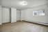 Spacious and bright room with sleek flooring, large window offering natural light, and a built-in closet space.