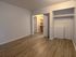 Inviting room with elegant wood flooring, spacious closet, and open doorway leading to versatile storage space.