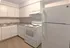 Charming kitchen with modern white cabinetry, a spacious countertop, and essential appliances, perfect for culinary creativity.