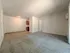 Bright and inviting open-concept living area with plush carpeting and cozy kitchen nook, perfect for a warm home atmosphere.
