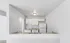 Modern kitchen with sleek white cabinets, granite countertops, and stainless steel sink, offering a bright and open design.