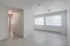 Bright apartment space with large windows, featuring an open layout and modern flooring.