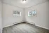 Bright and airy room with large windows and sleek laminate flooring, perfect for a cozy living space.
