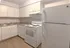 Charming kitchen with modern white cabinetry, spacious countertops, and sleek appliances for a cozy culinary experience.
