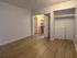 Spacious modern bedroom with elegant wood flooring and walk-in closet.