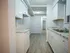 Modern galley kitchen with sleek white cabinetry, granite countertops, and durable wood-style flooring, perfect for culinary creativity.
