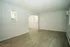 Spacious modern living space with sleek laminate flooring and soft neutral walls, featuring an open pass-through to the kitchen for easy entertaining.