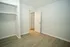 Bright, spacious room with elegant hardwood floors, open shelving, and a neutral color palette, perfect for customization.