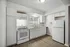 Modern kitchen with sleek white cabinets, spacious countertops, and stainless steel appliances, offering a bright and inviting cooking space.