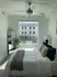 Bedroom with large window with a view and ceiling fan