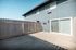 Charming outdoor patio with white fencing and modern sliding glass doors, perfect for relaxation and sunlight enjoyment.