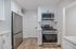Modern kitchen with stainless steel appliances, sleek cabinetry, and elegant hardwood floors.