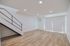 Elegant modern living space with sleek staircase, natural light, and stylish wood flooring.