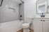Modern bathroom with sleek gray subway tiles, white bathtub, and elegant fixtures.