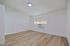 Bright, spacious room with modern wood flooring and a sleek air conditioning unit, perfect for a cozy, minimalist lifestyle.