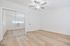 Bright and spacious bedroom with elegant mirrored closet doors, sleek ceiling fan, and stylish wood flooring.