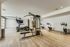 Modern fitness center with state-of-the-art exercise equipment, including treadmills, stationary bikes, and strength training machines on a sleek wood flooring.