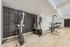 Modern apartment gym featuring state-of-the-art cardio equipment and sleek wooden flooring for a premium fitness experience.