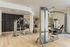 Elegant fitness center featuring state-of-the-art gym equipment and stylish wood flooring, perfect for an active lifestyle.
