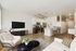 Modern open-plan apartment showcasing a sleek kitchen with stainless steel appliances, cozy living area with comfortable seating, and elegant decor.