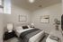 Elegant bedroom with modern decor featuring a plush bed, stylish nightstand lamps, and abstract wall art for a calming ambiance.