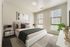 Bright and elegant bedroom with modern decor, large windows, and cozy bedding.