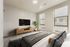 Bright and modern bedroom featuring a sleek mounted TV, elegant wooden console, and large windows letting in natural light.
