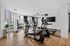 Bright and modern fitness center with sleek cardio equipment, hardwood floors, and large windows offering a vibrant city view.