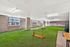 Modern indoor dog park featuring lush green turf and playful amenities for pets.