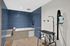 Modern pet grooming station featuring elegant blue tile walls, a spacious tub, and professional grooming equipment.