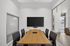 Modern conference room with a sleek wooden table, plush chairs, and a large flat-screen TV, perfect for productive meetings.