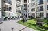 Modern apartment courtyard featuring stylish seating, lush artificial grass, and a sleek outdoor bar area.