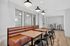 Modern communal dining area featuring sleek wooden tables, stylish leather bench seating, and contemporary lighting design.