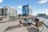 Inviting urban rooftop with modern seating and a barbecue grill, offering scenic city views and a relaxing outdoor atmosphere.