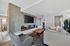 Community room with a cozy fireplace, elegant stone wall, plush seating, and stylish decor elements.