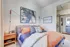Chic bedroom featuring stylish modern decor with patterned cushions, abstract artwork, and a cozy ambiance.