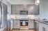 Modern kitchen with sleek gray cabinetry, stainless steel appliances, and a stylish open layout, perfect for culinary enthusiasts.