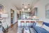 Chic open-concept living room with modern kitchen featuring sleek cabinetry, elegant lighting, and cozy seating area with plush blue sofa and stylish decor.