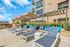 Elegant outdoor terrace with modern lounge chairs and umbrellas, perfect for relaxation under clear blue skies.