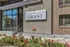 Elegant entrance of The Grant apartment building with modern design and vibrant landscaping.