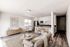Bright and inviting open-plan living room and kitchen featuring modern appliances, elegant furnishings, and abundant natural light.