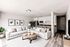 Inviting modern living room with elegant white decor, cozy sectional sofa, chic coffee table, and a seamless kitchen with sleek cabinetry.