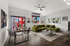 Chic urban living room with a vibrant green sofa, modern art, and wall-to-wall windows adorned with eclectic graffiti views.