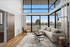 Bright, modern living room with floor-to-ceiling windows, elegant furnishings, and stunning outdoor views.