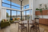 Bright and modern living space with floor-to-ceiling windows, stylish green sofas, and a chic dining area adjacent to a sleek kitchen.